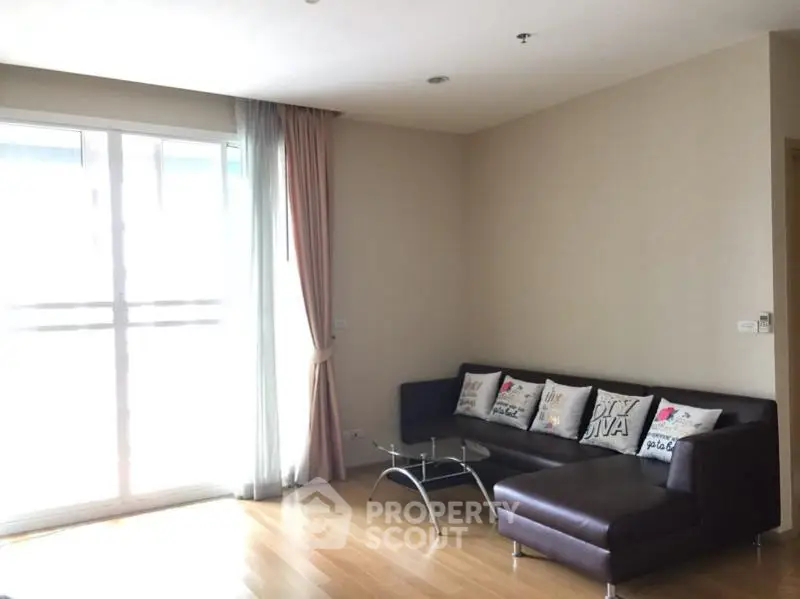 Spacious living room with modern sofa and natural light in a stylish apartment.