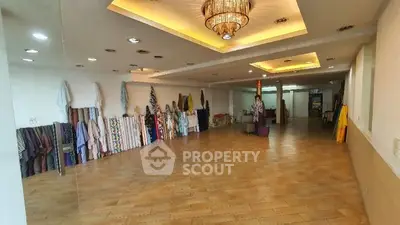 Spacious commercial interior with elegant lighting and wooden flooring, ideal for retail or showroom space.