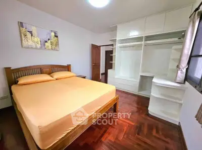 Spacious bedroom with wooden flooring and built-in wardrobe