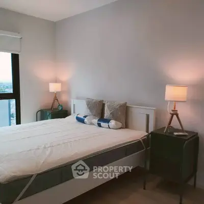 Modern bedroom with stylish lamps and large window offering city views