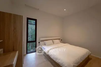 Modern minimalist bedroom with wooden accents and large window
