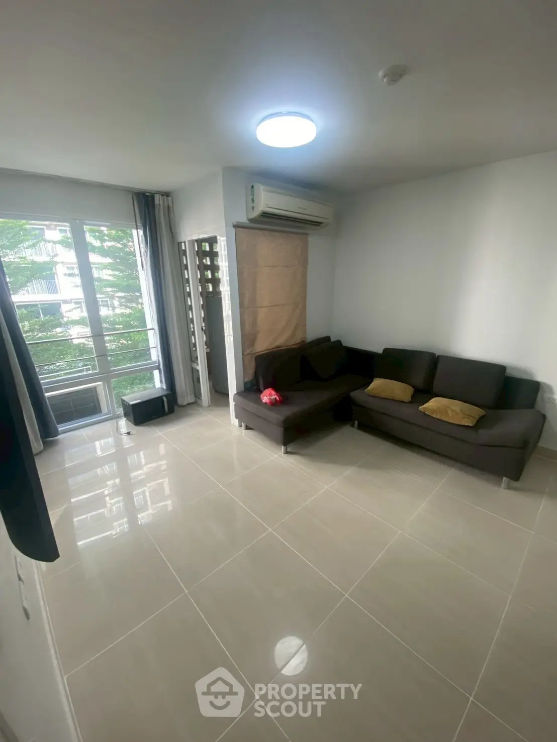 Spacious living room with modern sofa and large windows in a bright apartment