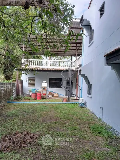 Charming two-story home with spiral staircase and spacious backyard, perfect for outdoor gatherings.