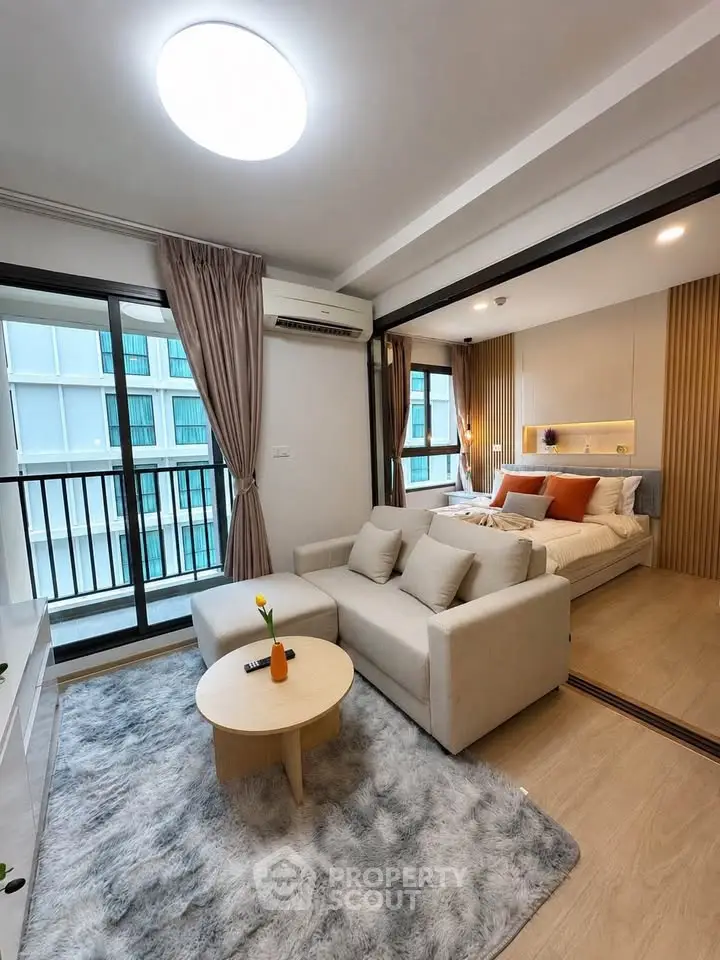 Modern open-plan living room with cozy bedroom and balcony view
