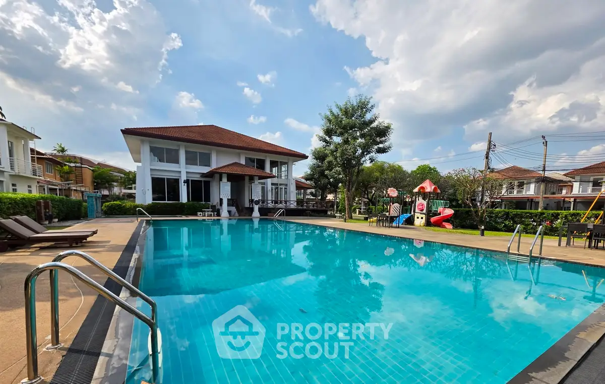 Luxurious residential complex with a pristine swimming pool and modern architecture under a clear blue sky.
