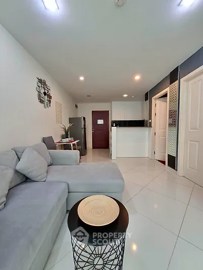 Modern living room with sleek furniture and open kitchen layout in a stylish apartment.