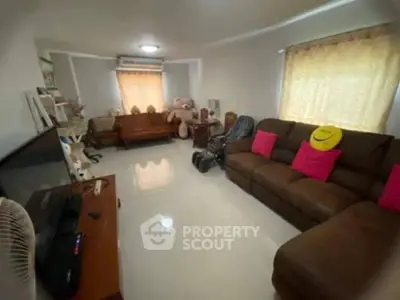 Spacious living room with cozy brown sofa and bright decor