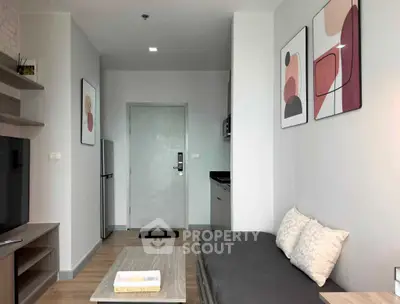 Modern living room with stylish decor and compact kitchen in a cozy apartment.