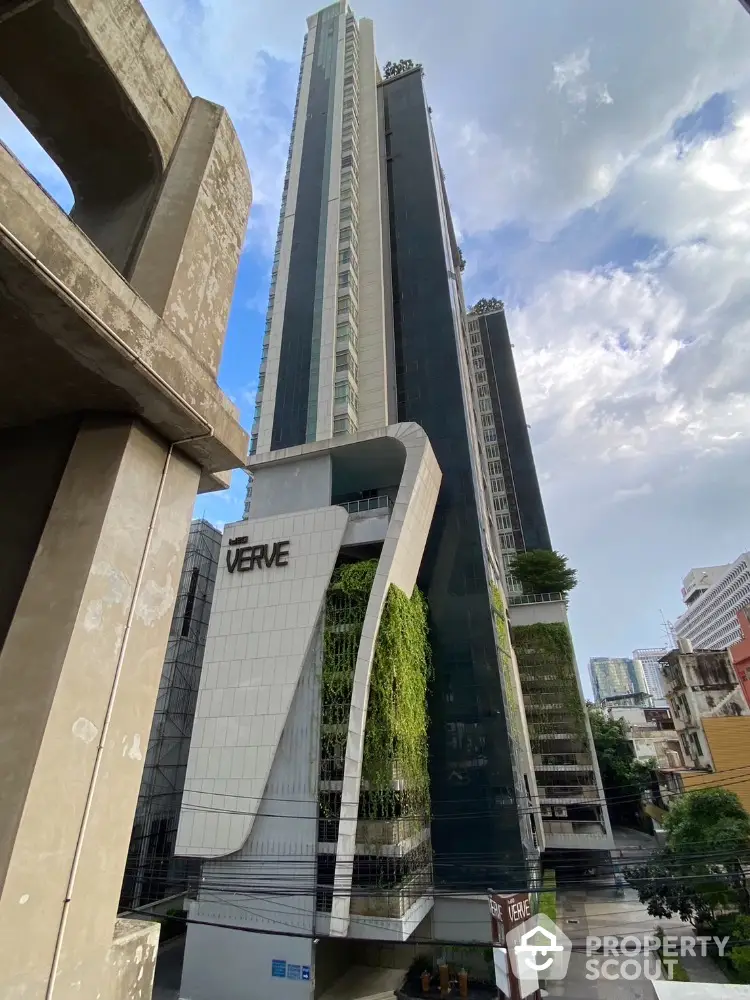 Stunning modern high-rise building with sleek architecture and lush greenery in urban setting.