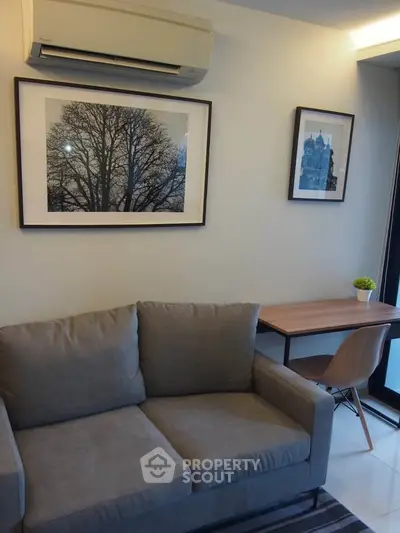 Modern living room with cozy sofa and stylish wall art, featuring a compact study area.