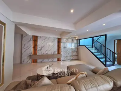 Luxurious modern living room with elegant marble accents and stylish staircase