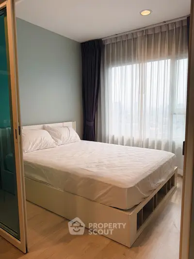 Cozy bedroom with large window and modern decor in a stylish apartment