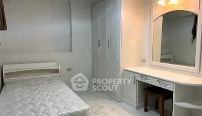 Cozy bedroom with built-in wardrobe and vanity, perfect for a serene retreat.