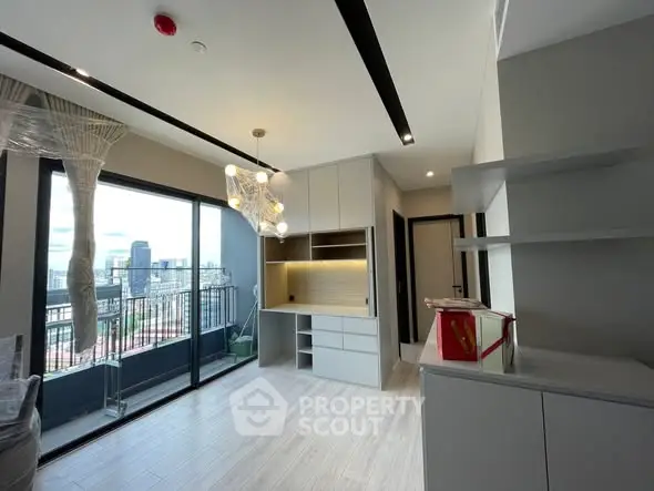 Modern living room with balcony and city view, featuring sleek design and ample natural light.