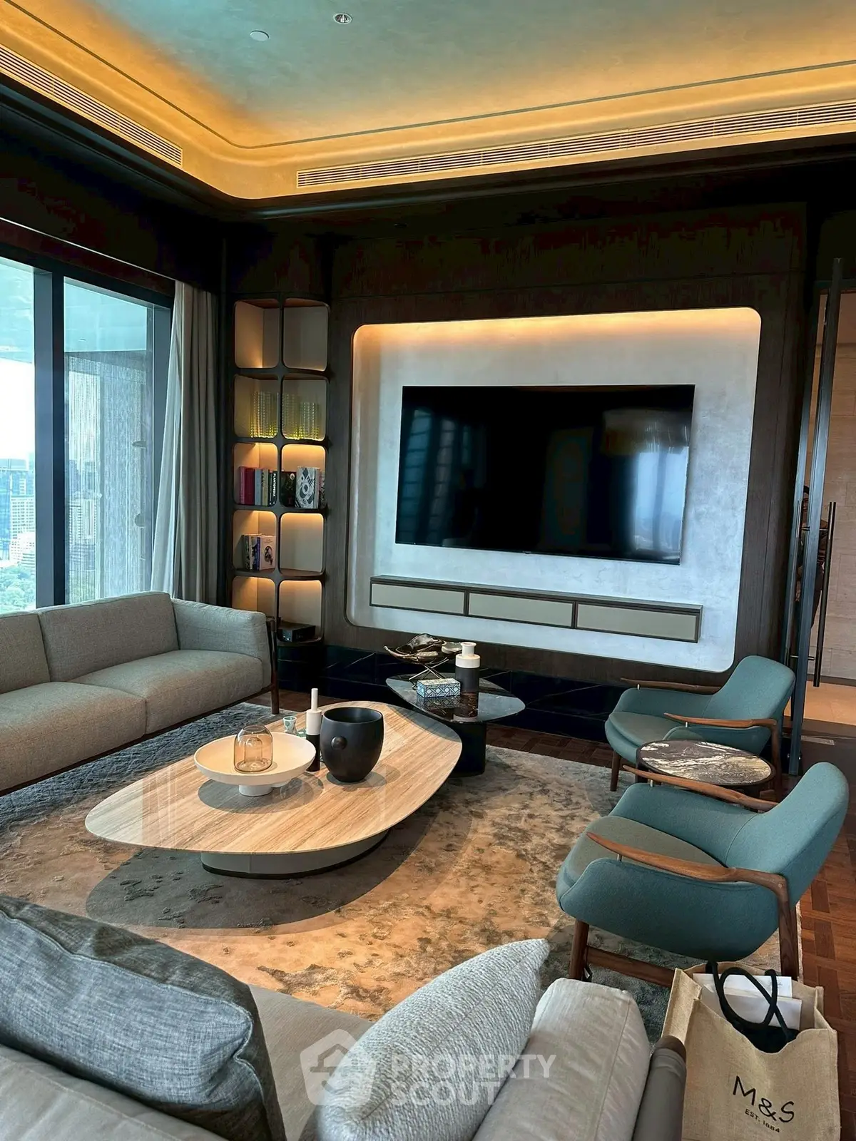 Luxurious modern living room with stylish furniture and large TV, perfect for relaxation and entertainment.