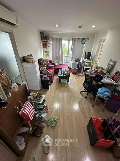 Cozy living room with wooden flooring, natural light, and eclectic decor, perfect for urban living.