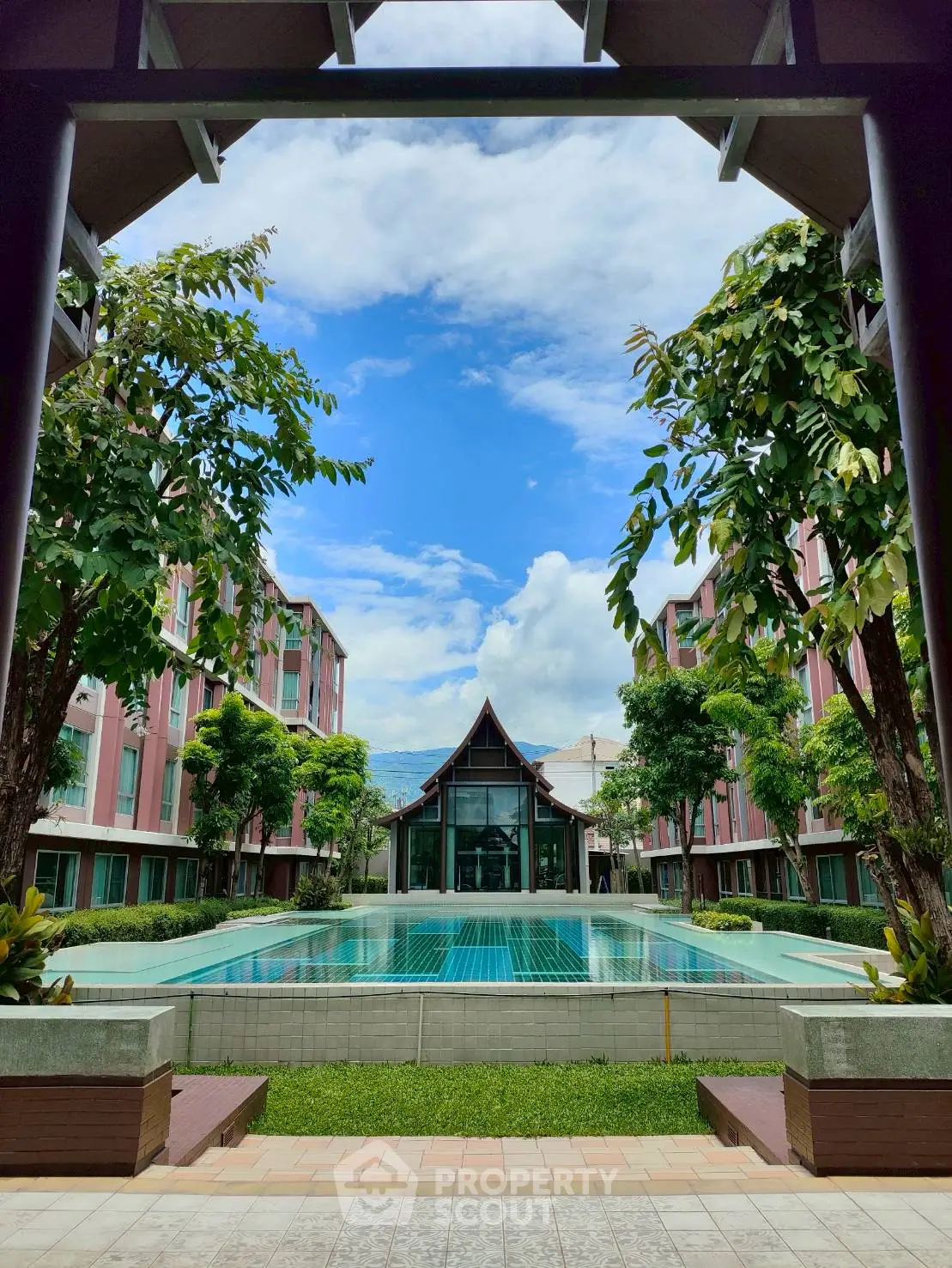 Stunning view of modern building with pool and lush greenery