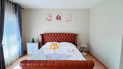 Cozy bedroom with elegant leather bed and soft lighting, perfect for relaxation.