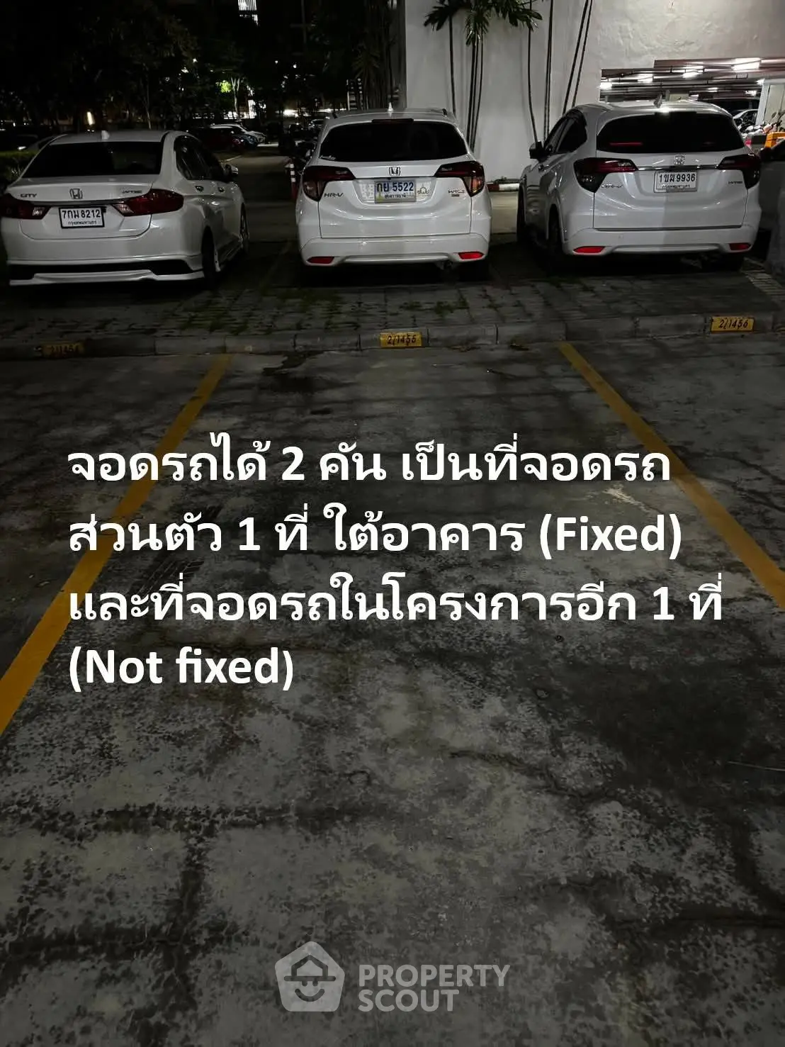 Parking area with cars in a residential or commercial building at night.