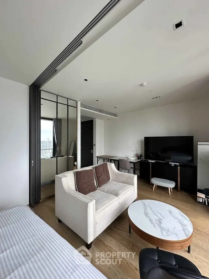 Modern living room with sleek furniture and city view, perfect for urban living.