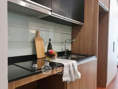 Modern kitchen with sleek black countertop and wooden cabinetry