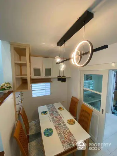 Charming dining area with modern lighting and elegant wooden chairs