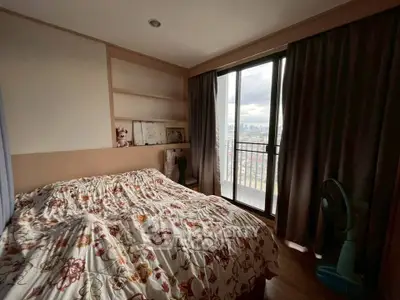 Cozy bedroom with floral bedding and balcony view in modern apartment