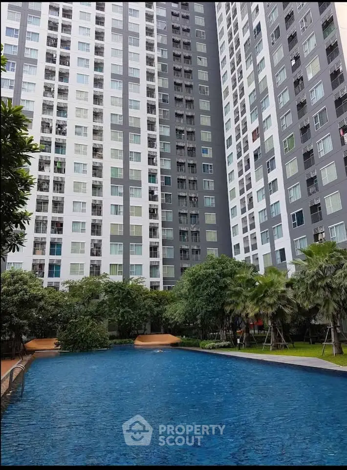 Modern high-rise apartment with lush garden and inviting swimming pool