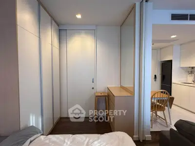 Modern bedroom with sleek wardrobe and cozy kitchen view