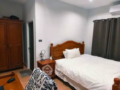 Cozy bedroom with wooden furniture and modern decor, perfect for relaxation.