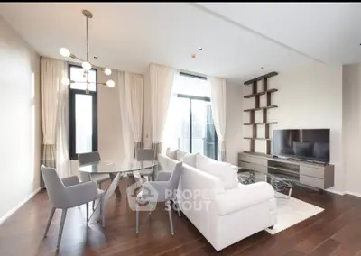 Luxurious modern living room with elegant furniture and large windows offering stunning city views.