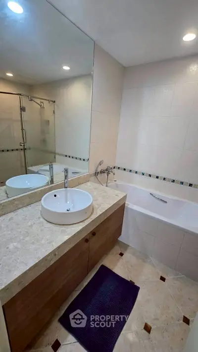 Modern bathroom with elegant fixtures and spacious bathtub, featuring a sleek design and calming ambiance.