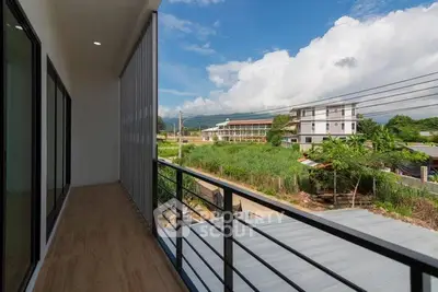 Spacious balcony with scenic view of lush greenery and modern buildings.