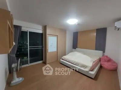 Spacious bedroom with modern decor and city view from balcony
