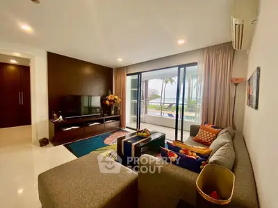 Spacious living room with modern decor and stunning ocean view through large windows.