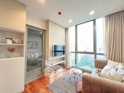 Modern living room with large windows and city view, featuring cozy seating and stylish decor.