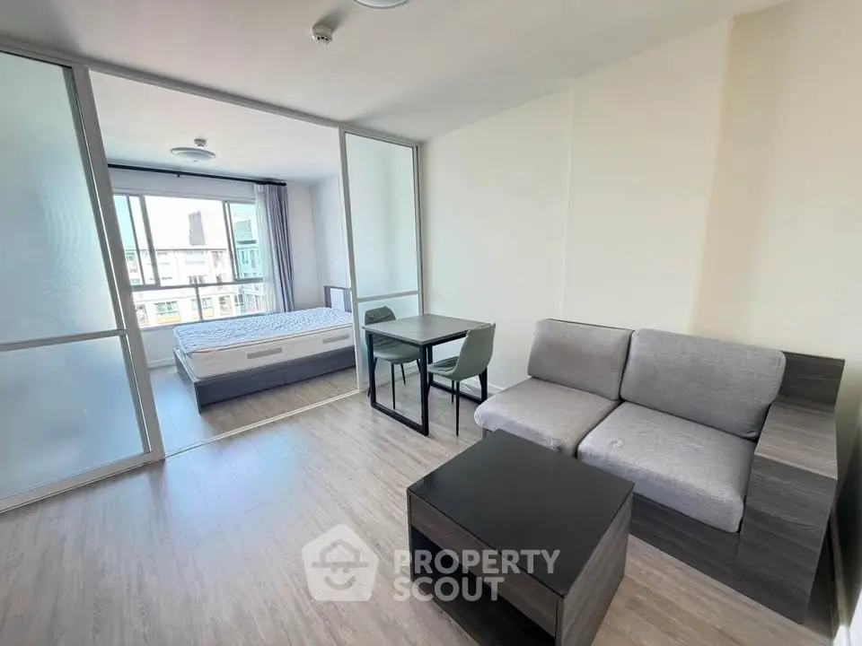 Modern studio apartment with open layout, featuring a cozy living area and bedroom with large windows.