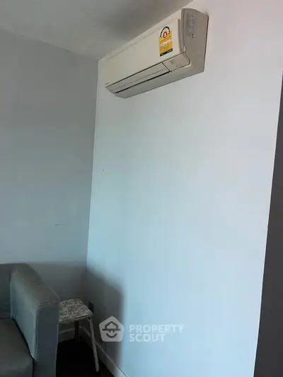 Modern living room with air conditioning unit and stylish gray sofa