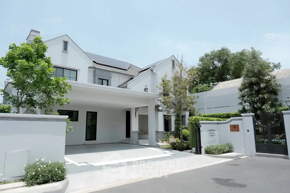 Luxurious modern white house with spacious driveway and lush greenery