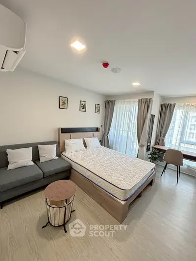 Modern bedroom with cozy seating and natural light, ideal for urban living.
