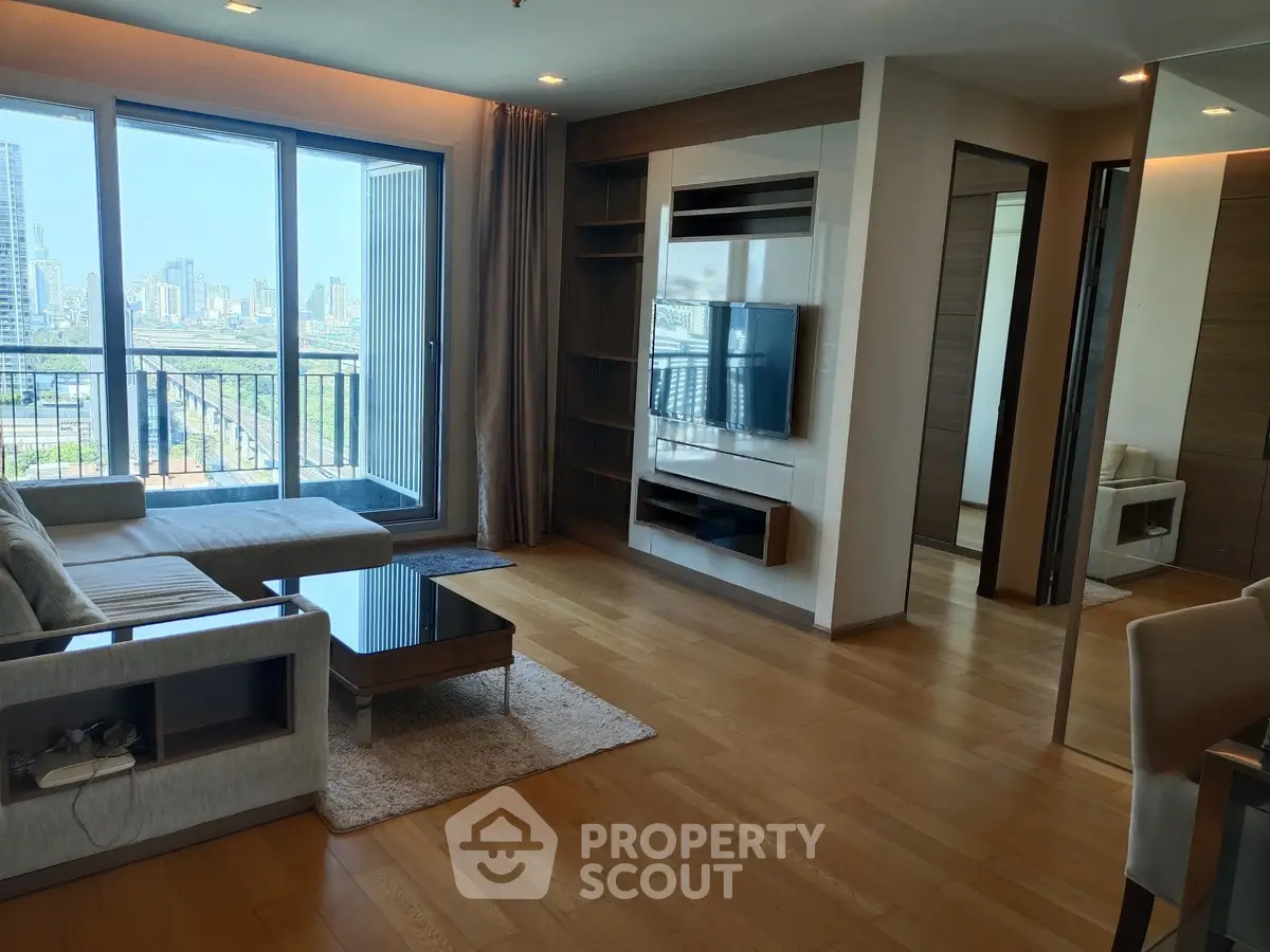 Modern living room with city view, featuring sleek furniture and large windows for natural light.
