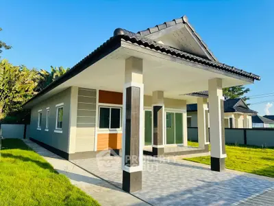 Modern single-story house with tiled roof and spacious driveway in a sunny suburban setting.