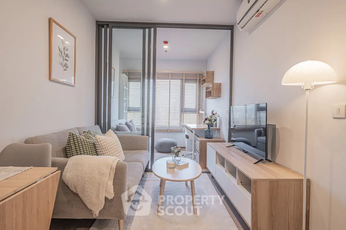 Modern living room with cozy decor and natural light, featuring a stylish sofa and entertainment unit.