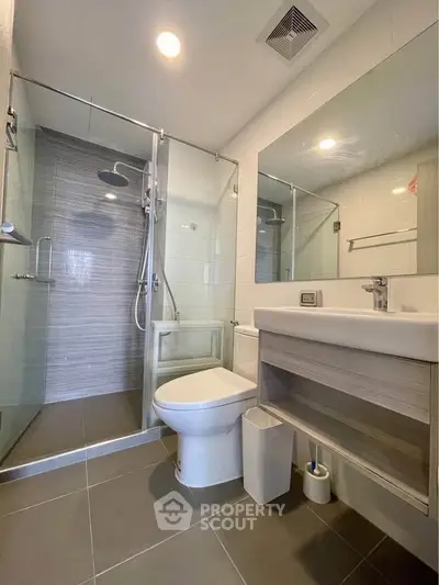 Modern bathroom with glass shower and sleek fixtures in a contemporary apartment.