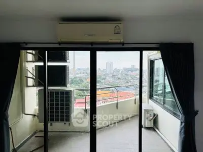 Spacious balcony with city view and air conditioning unit in modern apartment.