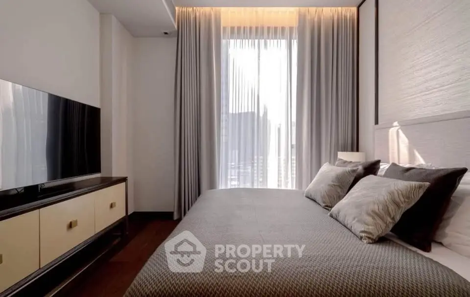 Modern bedroom with elegant decor and natural light through large window.