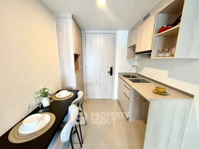 Modern kitchen with sleek cabinetry and dining area in a stylish apartment