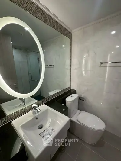 Modern bathroom with illuminated mirror and sleek fixtures