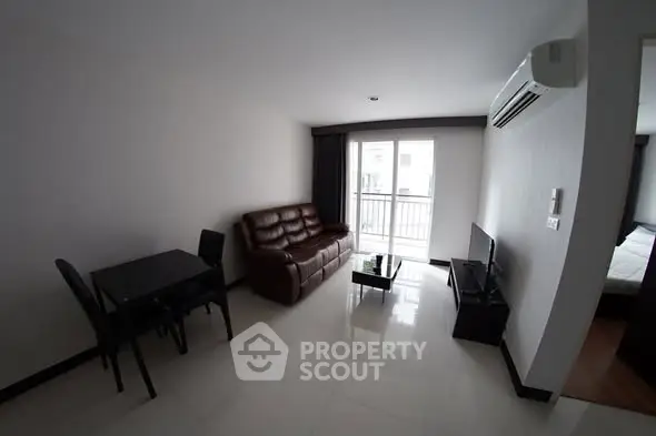 Modern living room with sleek furniture and balcony access in a stylish apartment.