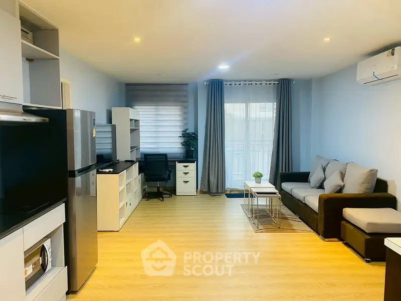 Modern living room with sleek furniture and natural light, featuring a cozy sofa and work desk.